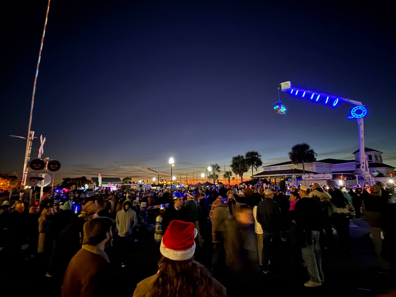 Shrimpy on crane at dusk with crowd below