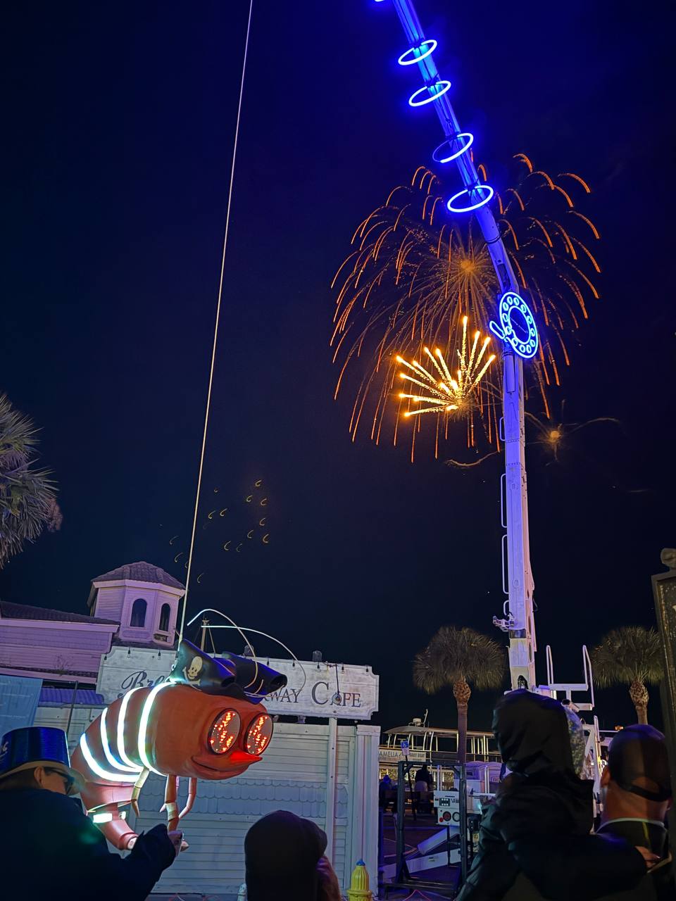 Shrimpy below cascading fireworks with spectators